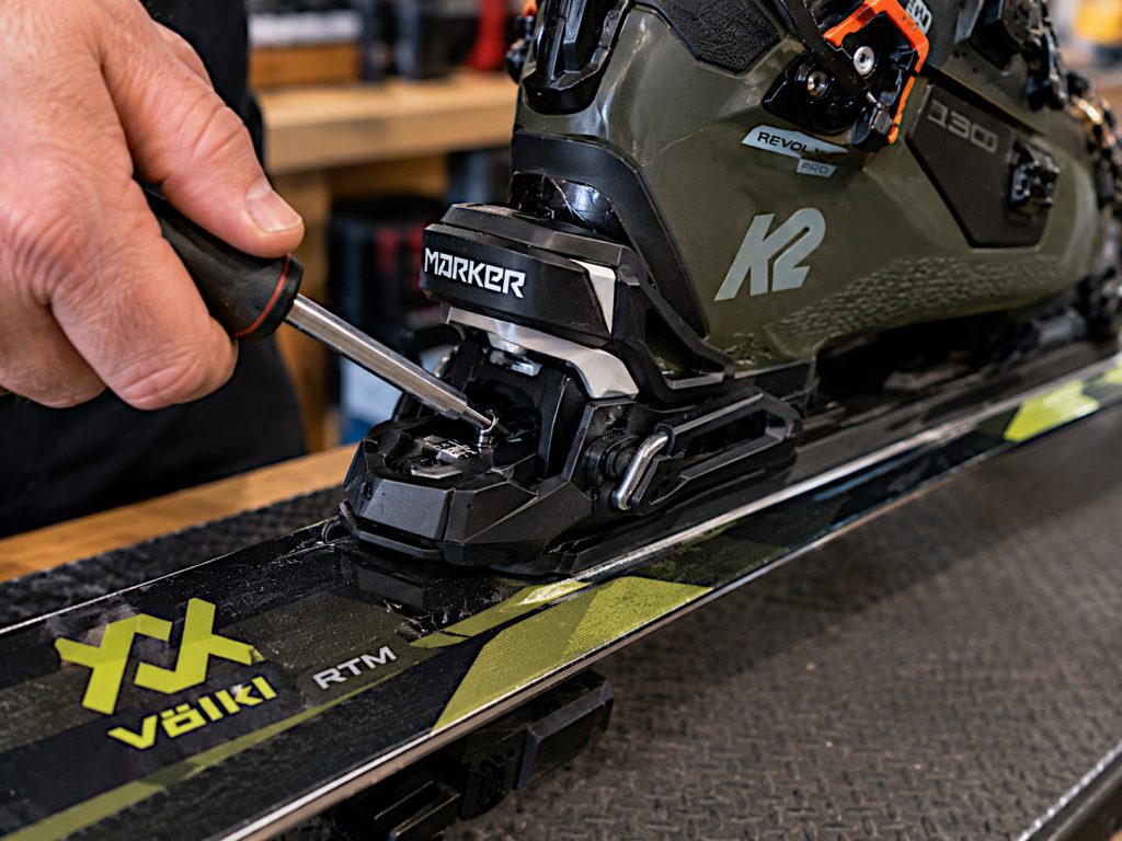 Ski binding being adjusted by a tech